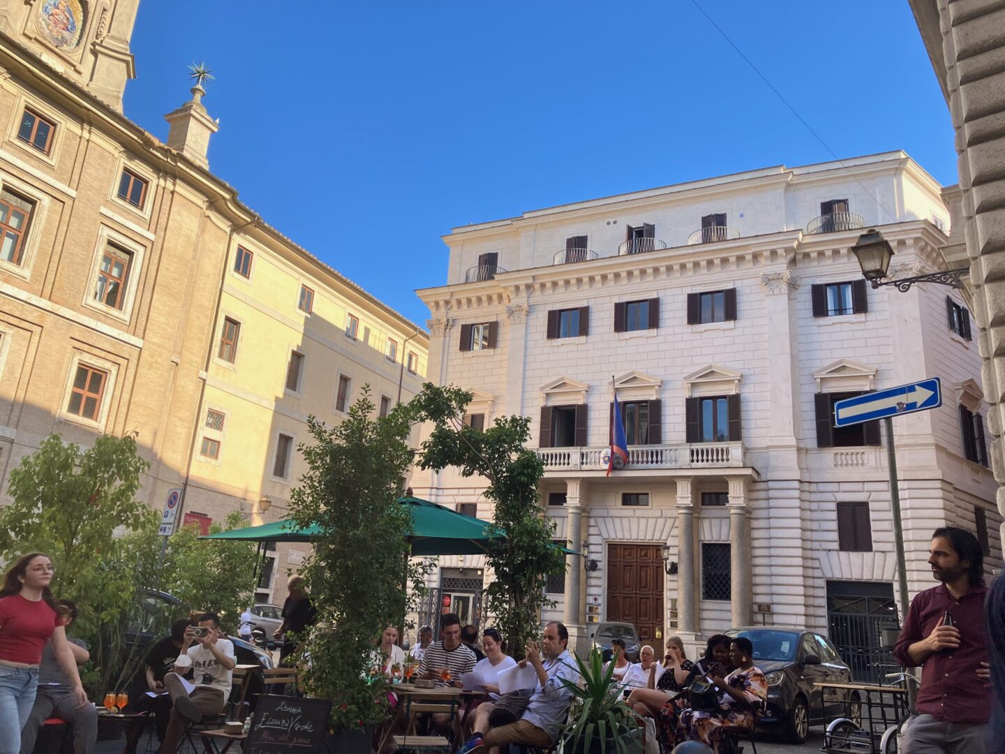 A group of people sitting on a bench in front of a building.