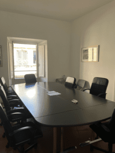 A black conference table with papers.