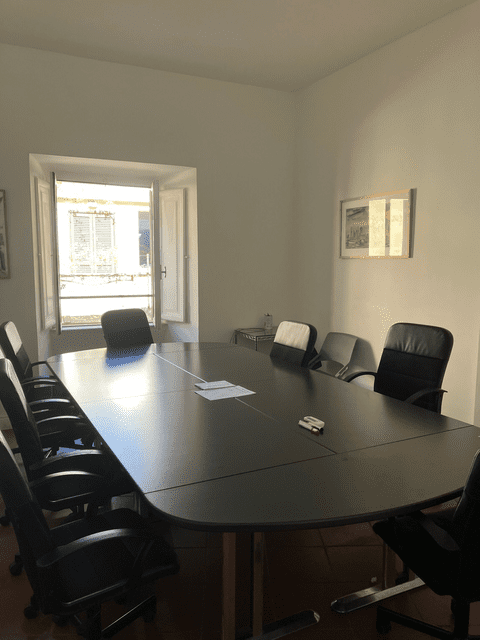 A black conference table with papers.